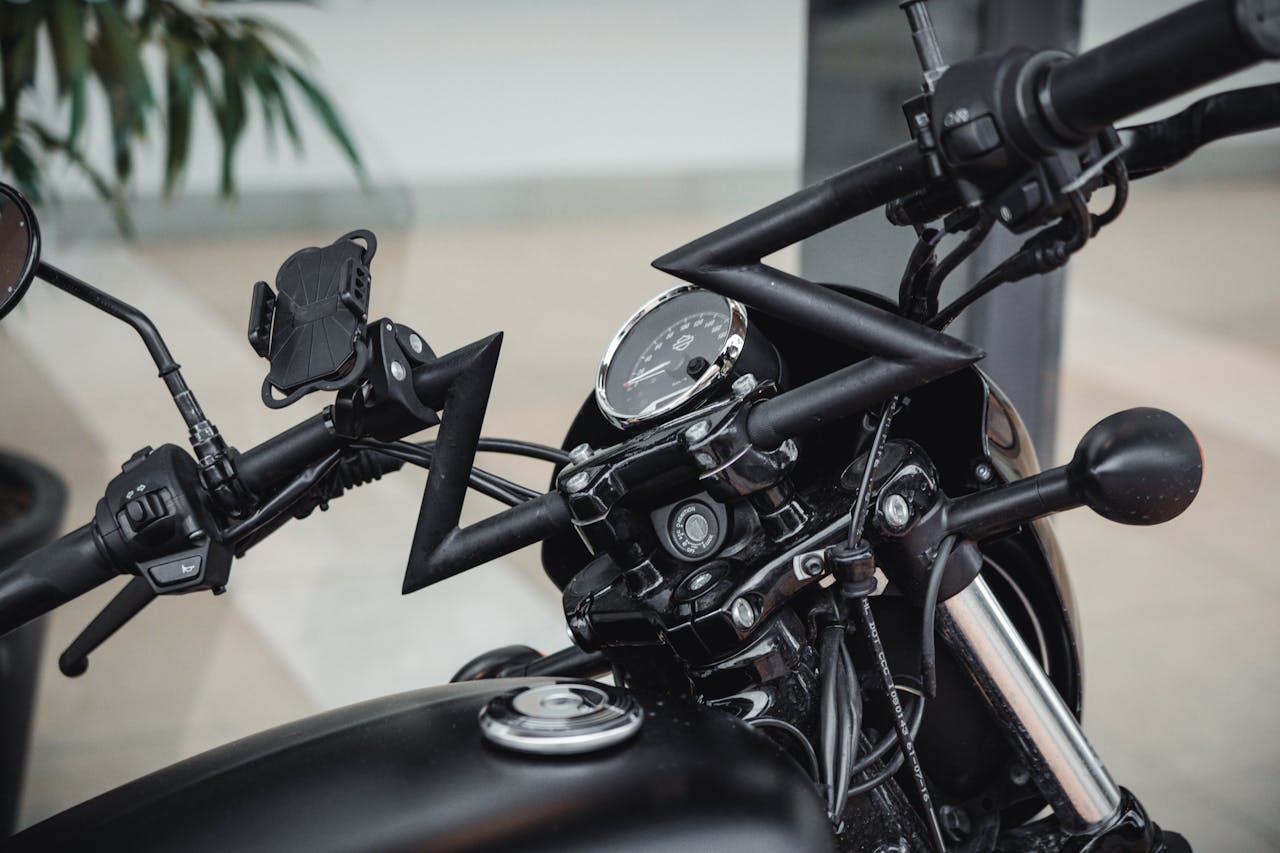 Detailed view of a black motorcycles handlebars and gauges with modern design and accessories.